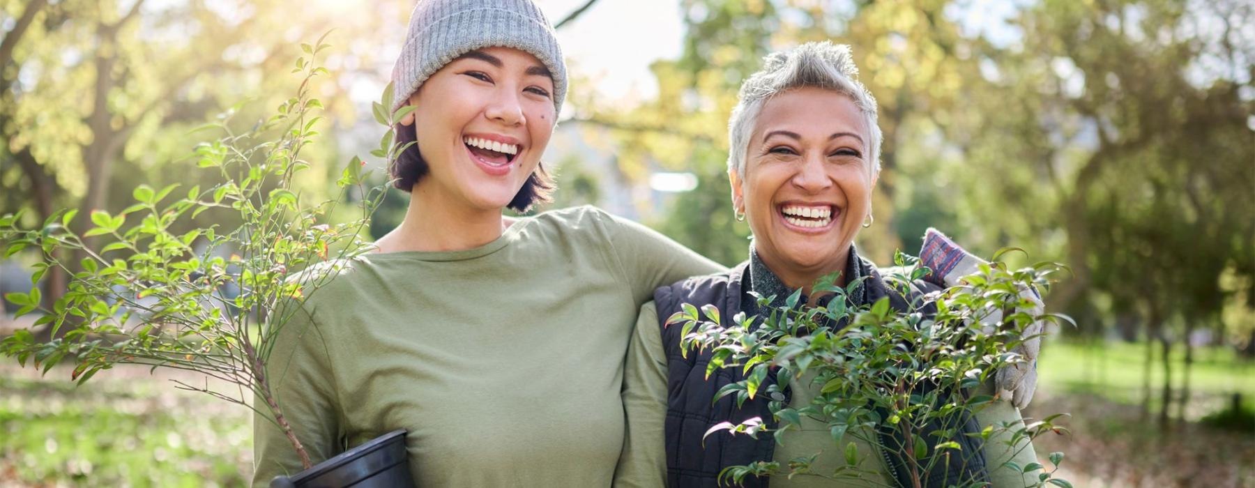 a couple of women holding plants