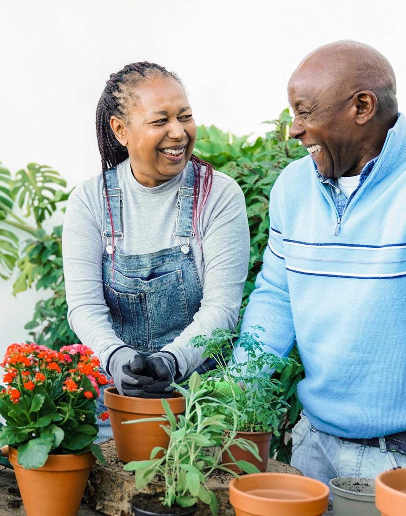 a man and a woman smiling while gardening