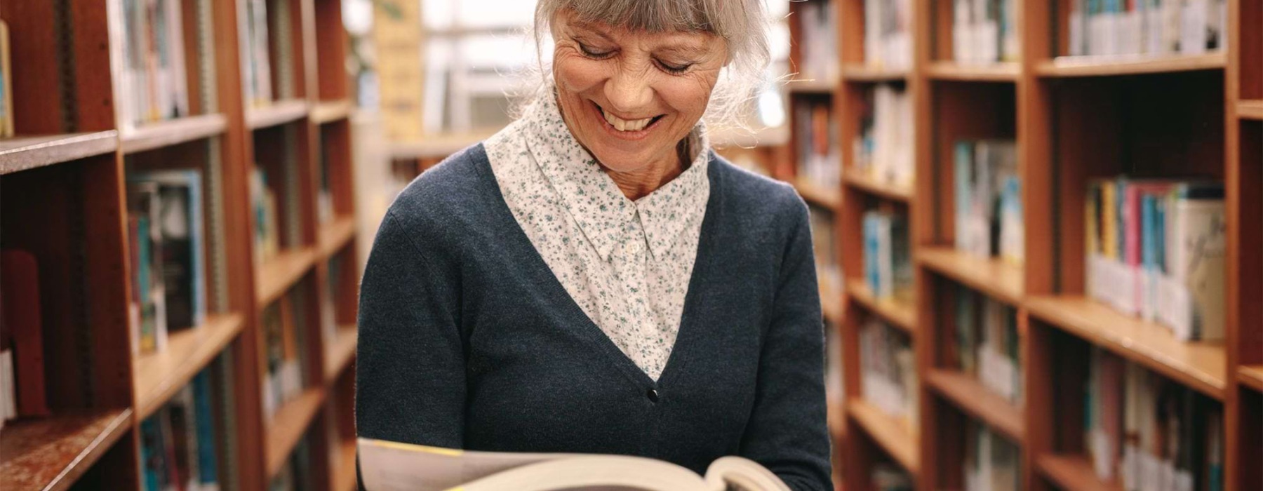 a woman reading a book in a library