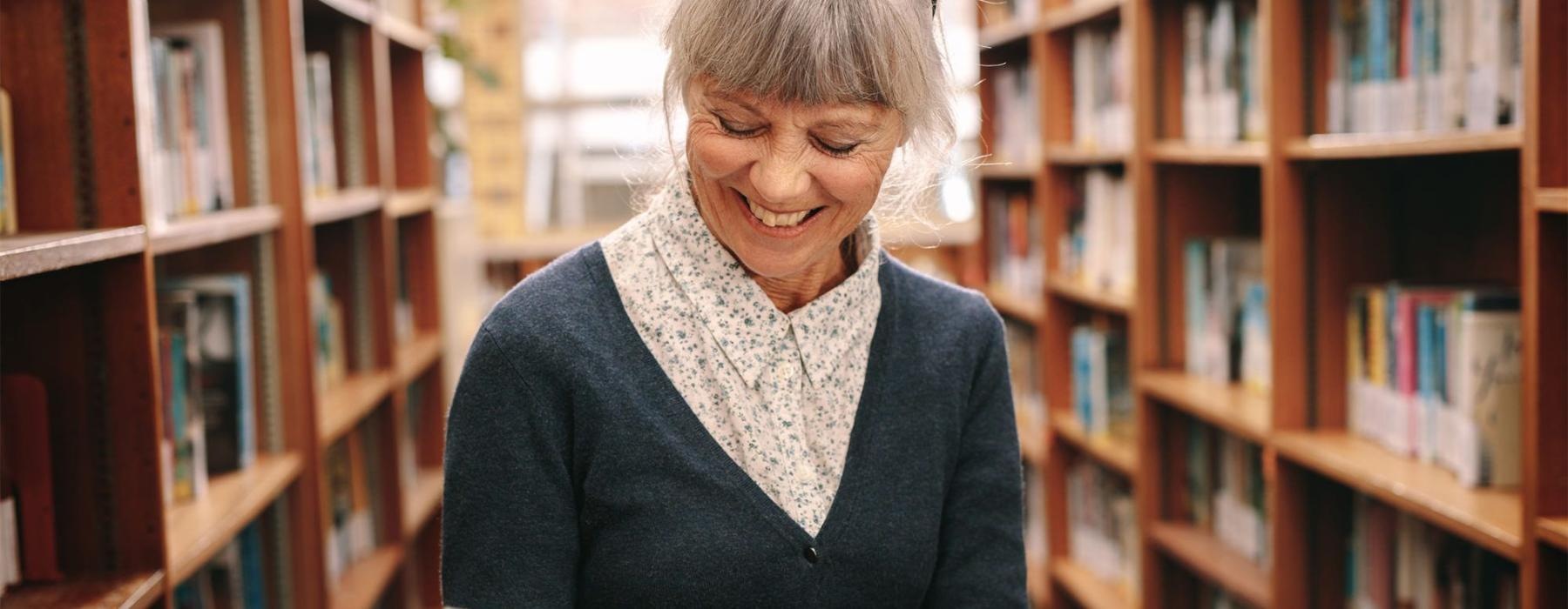 a woman reading a book in a library